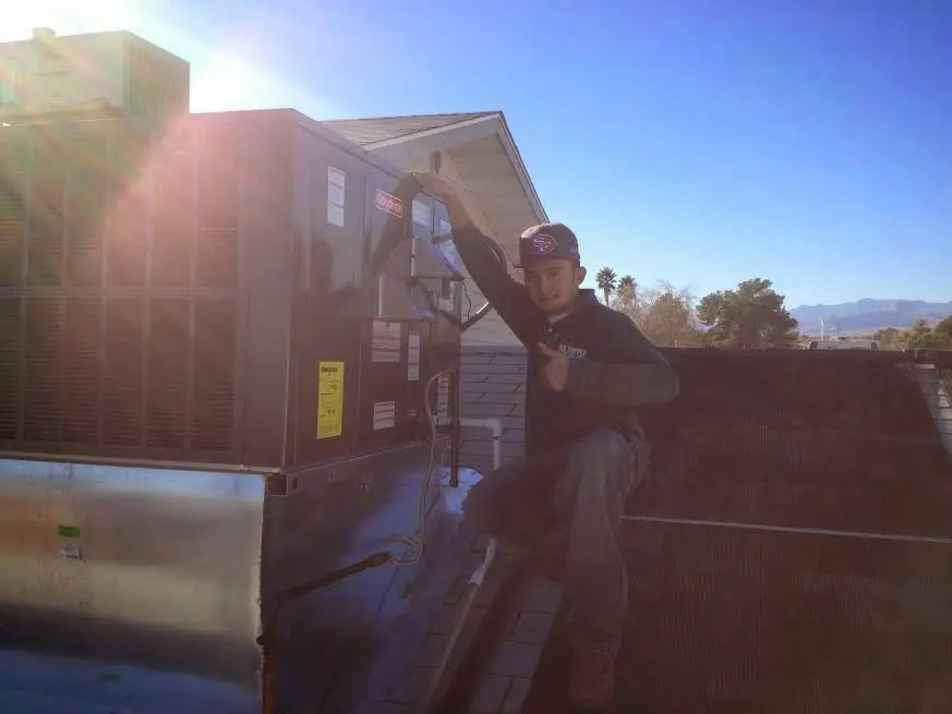 HVAC technician performing Boiler Repair on a rooftop unit in Melvindale